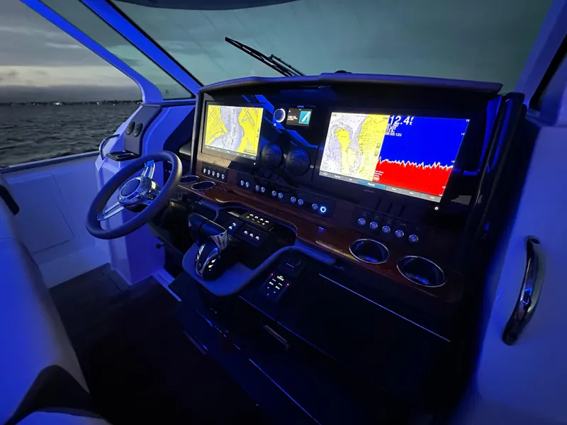 Slide: The Image of Helm of 2020 Tiara Yachts 43 LS with advanced navigation displays at dusk. - 16