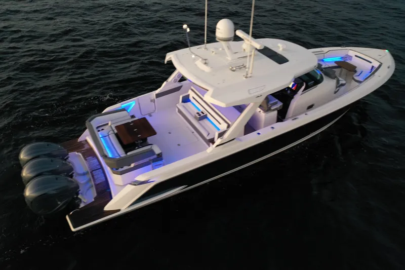 Slide: The Image of 2020 Tiara Yachts 43 LS luxury boat with illuminated deck, cruising on dark waters. - 2