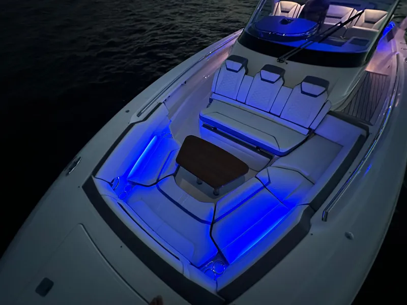 Slide: The Image of 2020 Tiara Yachts 43 LS with blue LED lighting and elegant seating arrangement. - 20