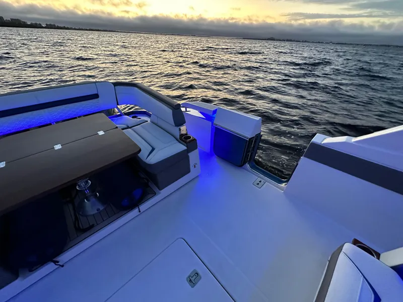 Slide: The Image of 2020 Tiara Yachts 43 LS on water at sunset, featuring elegant seating and ambient lighting. - 24