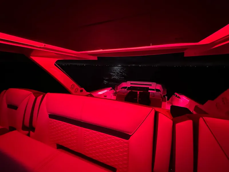Slide: The Image of Red-lit interior of a 2020 Tiara Yachts 43 LS at night, showcasing luxury seating. - 37