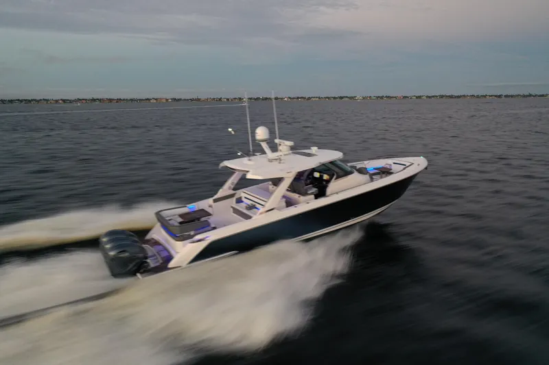 Slide: The Image of 2020 Tiara Yachts 43 LS cruising swiftly on open water at dusk. - 8