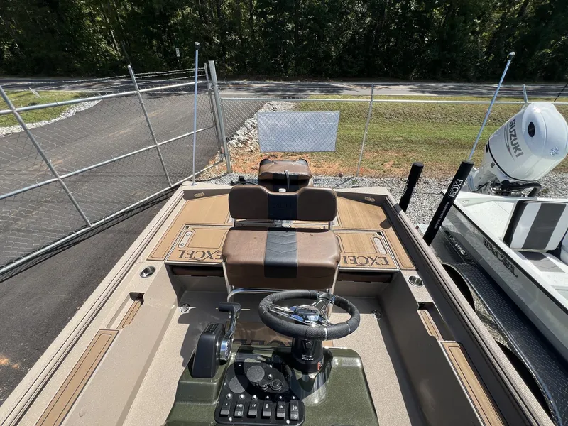 Slide: The Image of 2025 Excel New Bay Pro 230 boat interior with steering wheel and seating. - 13