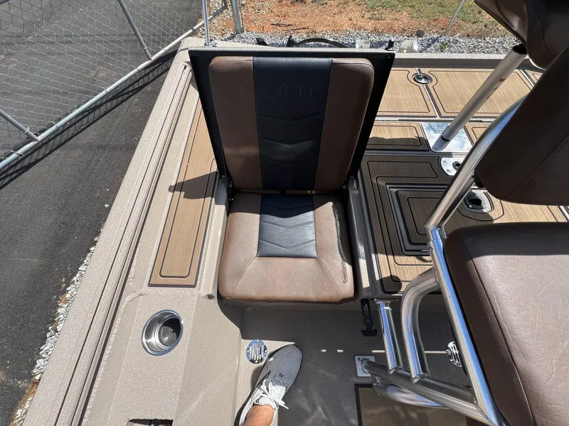 Slide: The Image of 2025 Excel New Bay Pro 230 boat interior with brown seating and stainless steel fixtures. - 15