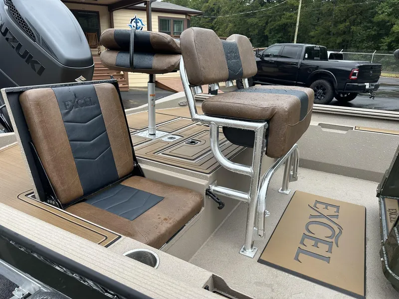 Slide: The Image of 2025 Excel New Bay Pro 230 boat interior with brown and black seating, Suzuki engine visible. - 5