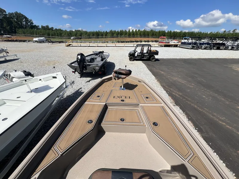 Slide: The Image of 2025 Excel New Bay Pro 230 boat displayed in a marina with other vessels. - 9