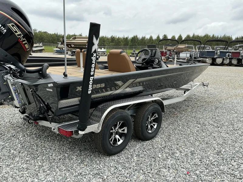 Slide: The Image of 2025 Xpress Hyper-Lift Crappie Series H20 boat on trailer, gravel lot background. - 11