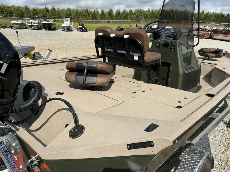 Slide: The Image of 2025 Excel Bay Pro 203 ELITE boat with seating and control console, parked outdoors. - 5