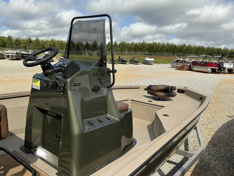 Slide: The Image of 2025 Excel Bay Pro 203 Elite boat with console, parked outdoors under cloudy sky. - 8