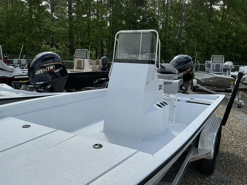 Slide: The Image of 2025 Xpress Hyper-Lift Bay Series 210 BAY-175 HP boat with Yamaha engines, parked outdoors. - 2
