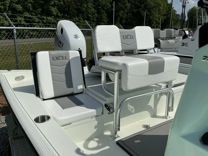 Slide: The Image of 2025 Excel Bay Pro 203 ELITE boat interior with white and gray seating, Suzuki engine visible. - 4