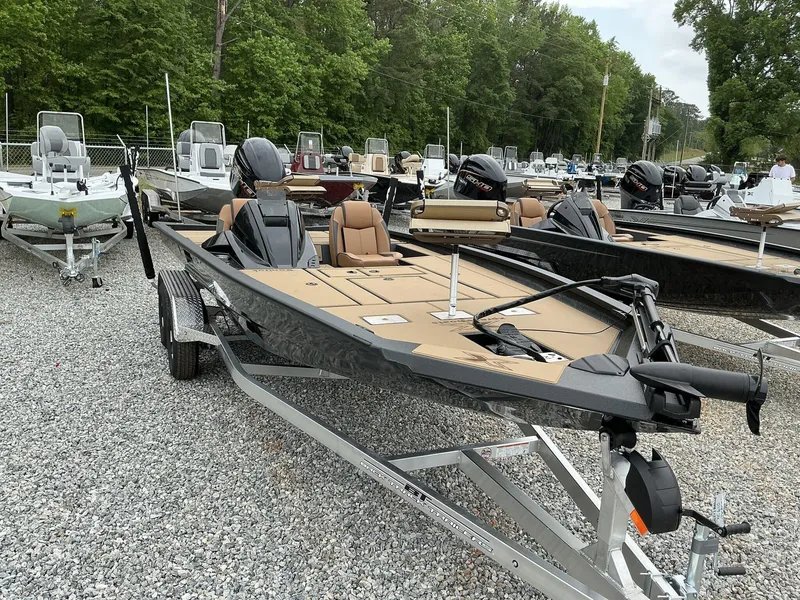 Slide: The Image of 2025 Xpress Hyper-Lift Crappie Series H20 boat on trailer, surrounded by trees and other boats. - 2