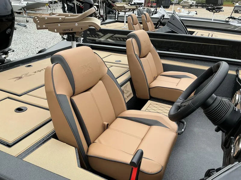 Slide: The Image of 2025 Xpress Hyper-Lift Crappie Series H20 boat interior with tan seats and steering wheel. - 7