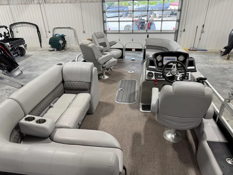 Slide: The Image of 2020 Ranger 223 FC boat interior with gray seating and steering console in a showroom. - 13