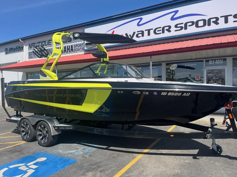 Slide: The Image of 2014 Correct Craft 230 TEAM EDITION boat with vibrant yellow accents, parked outside a water sports store. - 13
