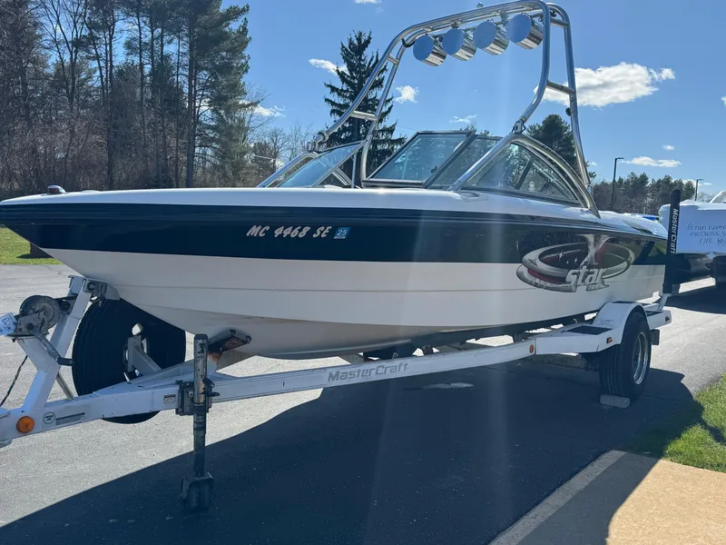 Slide: The Image of 2001 MasterCraft XStar boat on trailer, parked outdoors under clear sky. - 3