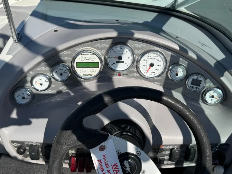Slide: The Image of Dashboard of a 2001 MasterCraft XStar boat with gauges and steering wheel. - 8