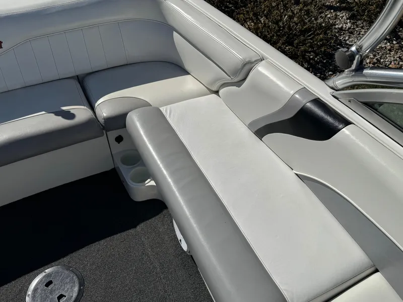 Slide: The Image of 2001 MasterCraft XStar boat interior with white and gray seating, cup holders, and sleek design. - 9