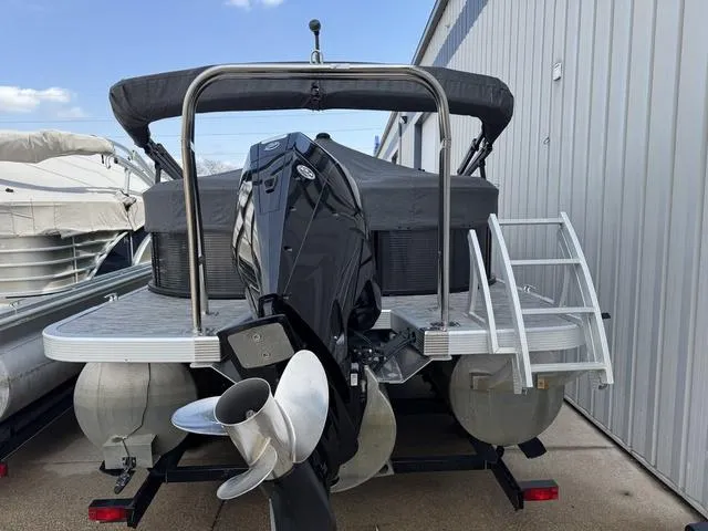 Slide: The Image of 2020 Bennington 22 SSRX pontoon boat with outboard motor, docked beside a metal building. - 4