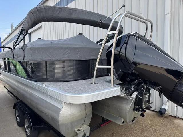 Slide: The Image of 2020 Bennington 22 SSRX pontoon boat with cover and outboard motor, parked on trailer. - 5