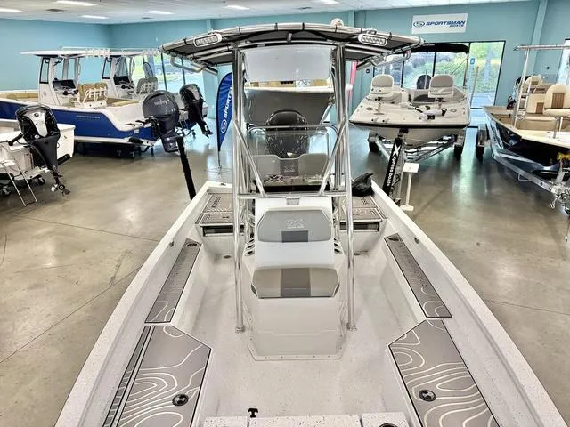 Slide: The Image of 2023 Xpress Boats H22B center console boat displayed in showroom with modern design. - 5