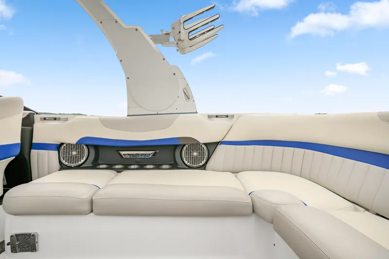 Slide: The Image of 2015 Malibu Wakesetter 24 MXZ interior with white and blue seating, speakers, and wakeboard tower. - 13