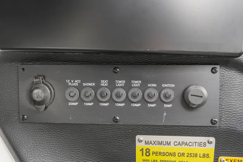 Slide: The Image of Control panel of a 2015 Malibu Wakesetter 24 MXZ boat with various switches and capacity label. - 20