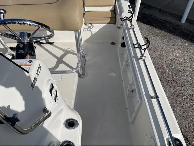 Slide: The Image of 2019 NauticStar 215 XTS boat interior with steering wheel and rod holders. - 11
