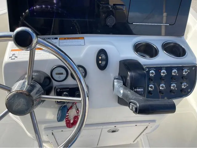 Slide: The Image of 2019 NauticStar 215 XTS boat console with steering wheel and controls. - 13
