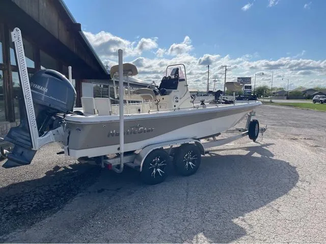 Slide: The Image of 2019 NauticStar 215 XTS boat on trailer, parked outdoors under a sunny sky. - 3