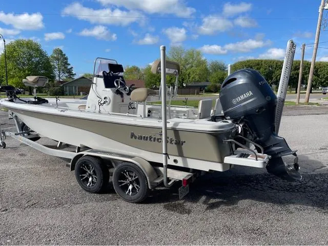 Slide: The Image of 2019 NauticStar 215 XTS boat on trailer with Yamaha outboard motor, parked outdoors. - 4
