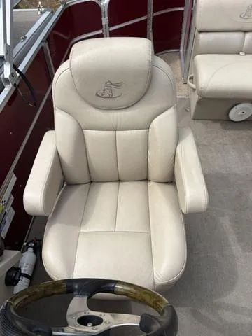Slide: The Image of 2014 Misty Harbor Boats CR 225 captain's chair with beige upholstery and steering wheel. - 13