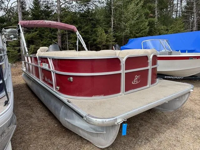 Slide: The Image of 2014 Misty Harbor Boats CR 225 pontoon with red exterior, parked outdoors near trees. - 3