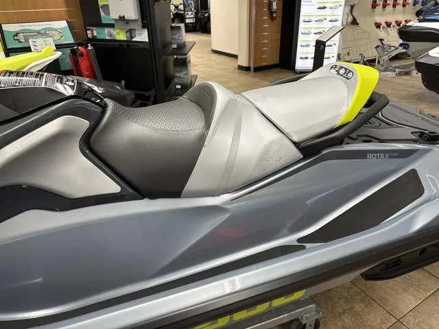 Slide: The Image of 2025 Sea-Doo Waverunner RXT-X in showroom, featuring sleek design and comfortable seating. - 13
