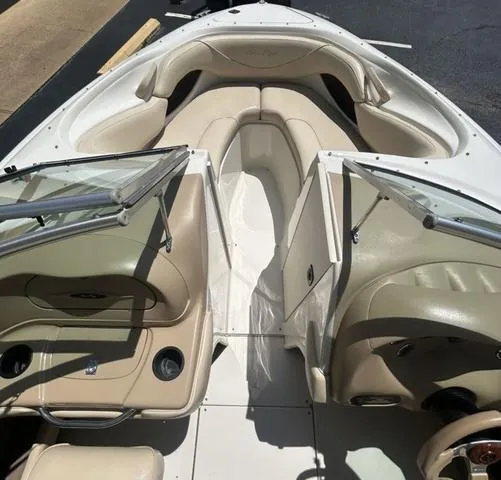 Slide: The Image of 2000 Sea Ray 210 Signature boat interior with beige seating and open windshield. - 6