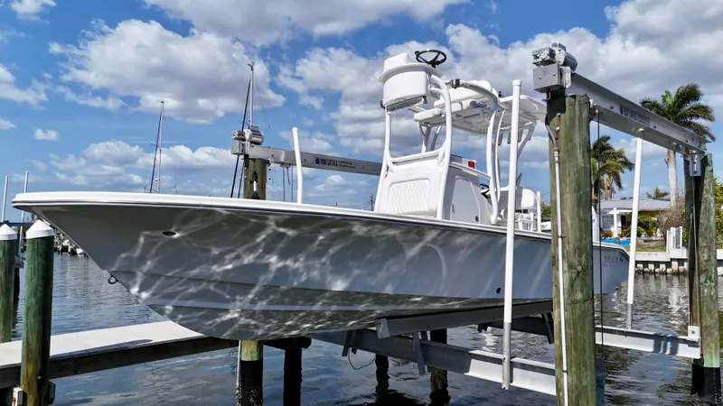 Slide: The Image of 2022 Xplor x24 Andros Mercury boat on lift, clear sky, waterfront view. - 6