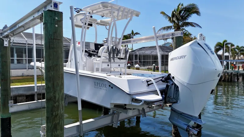 Slide: The Image of 2022 Xplor x24 Andros boat with Mercury 300 engine on lift, docked by waterfront homes. - 7