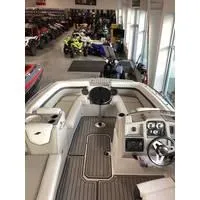 Slide: The Image of 2023 Starcraft SVX 191 OB boat interior in showroom, featuring steering console and seating. - 2