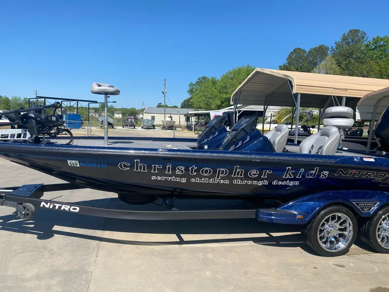 Slide: The Image of 2022 Nitro Z21 XL Pro boat with custom "Christopher Kids" design, parked outdoors. - 1
