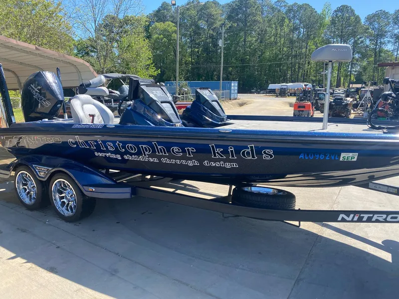 Slide: The Image of 2022 Nitro Z21 XL Pro boat with "Christopher Kids" design, parked outdoors. - 2