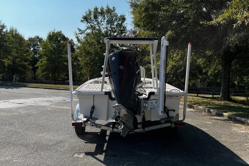 Slide: The Image of 2025 Mako Pro Skiff 18 Patriot Edition boat on trailer, parked outdoors. - 4