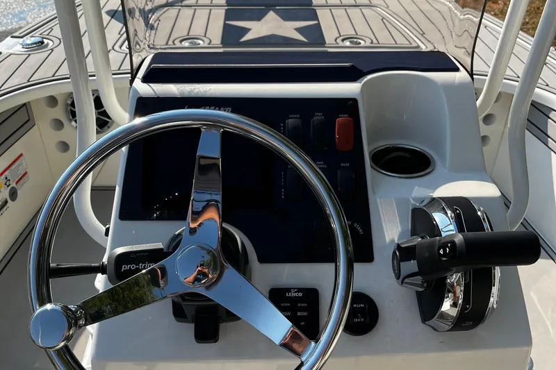 Slide: The Image of 2025 Mako Pro Skiff 18 Patriot Edition boat console with steering wheel and controls. - 6
