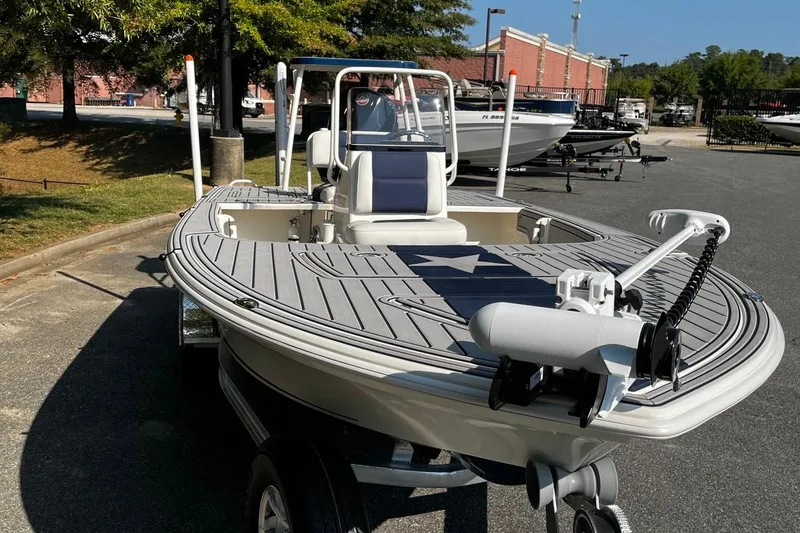 Slide: The Image of 2025 Mako Pro Skiff 18 Patriot Edition boat on trailer, parked outdoors. - 7