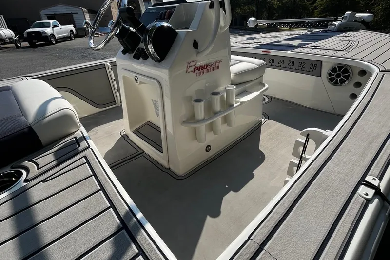 Slide: The Image of 2025 Mako Pro Skiff 18 Patriot Edition interior with steering console and rod holders. - 8