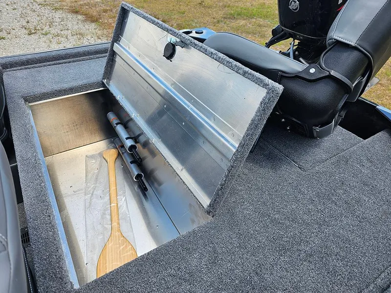 Slide: The Image of 2025 Tracker Bass Tracker Classic XL boat storage compartment with paddle and fishing rods. - 10