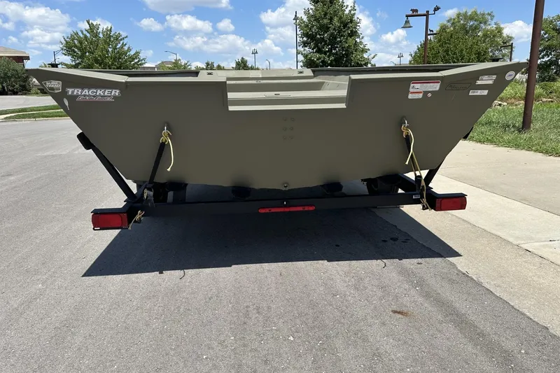Slide: The Image of 2025 Tracker Grizzly 2072 Utility boat on trailer, parked on a sunny street. - 2