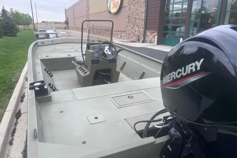 Slide: The Image of 2024 Tracker Grizzly 2072 CC boat with Mercury engine, parked outside a store. - 13