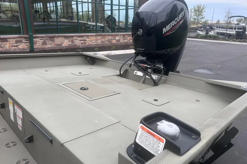 Slide: The Image of 2024 Tracker Grizzly 2072 CC boat with Mercury outboard motor, parked outdoors. - 14
