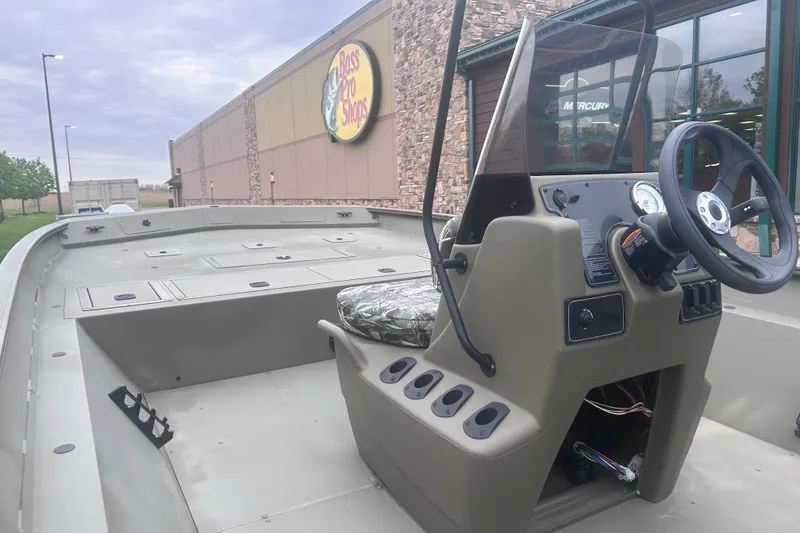 Slide: The Image of 2024 Tracker Grizzly 2072 CC boat at Bass Pro Shops, featuring a spacious deck and console. - 15