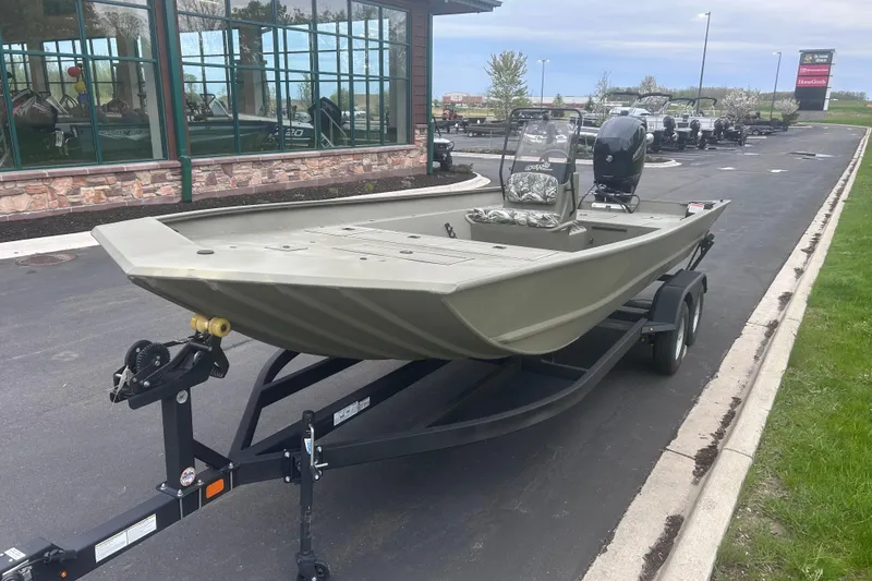 Slide: The Image of 2024 Tracker Grizzly 2072 CC boat on trailer, parked outside a building. - 18